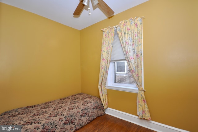 bedroom featuring ceiling fan, baseboards, and wood finished floors