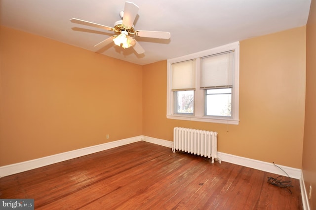 unfurnished room featuring radiator heating unit, baseboards, ceiling fan, and wood finished floors