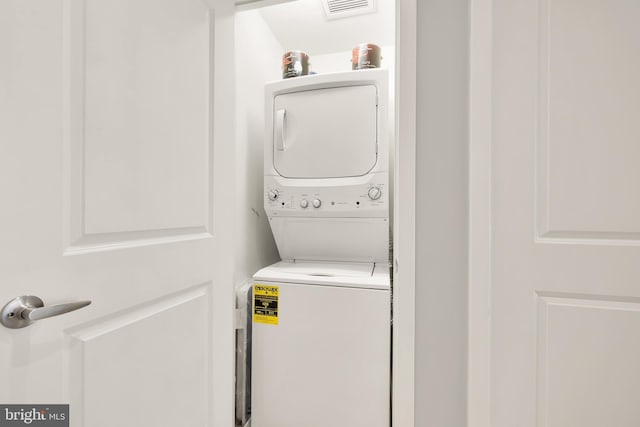 washroom featuring laundry area, stacked washer / dryer, and visible vents