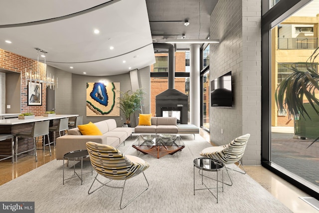 living area featuring recessed lighting, floor to ceiling windows, brick wall, and a wood stove