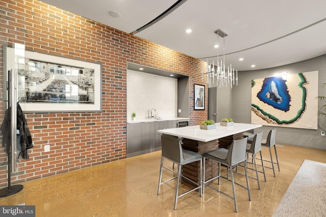 dining space featuring recessed lighting, light speckled floor, and brick wall