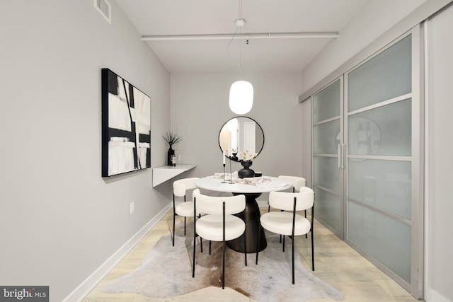 dining space with visible vents, baseboards, and light wood-style floors