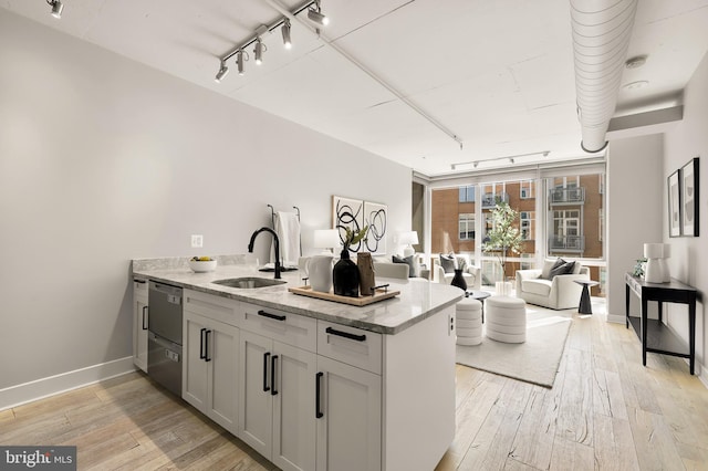 kitchen with a sink, light wood-type flooring, a peninsula, and rail lighting