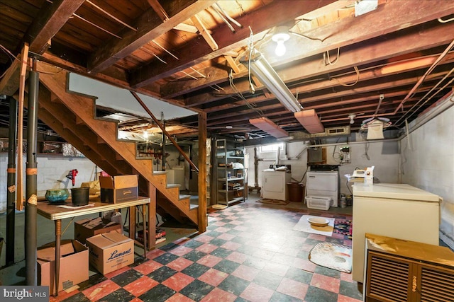 below grade area with tile patterned floors, stairway, independent washer and dryer, and refrigerator