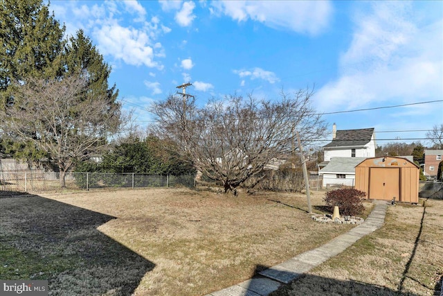 view of yard featuring an outbuilding, fence, and a shed