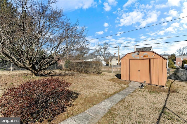 view of yard with an outbuilding, a shed, and a fenced backyard