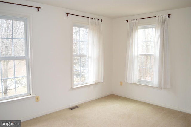 carpeted spare room with baseboards and visible vents