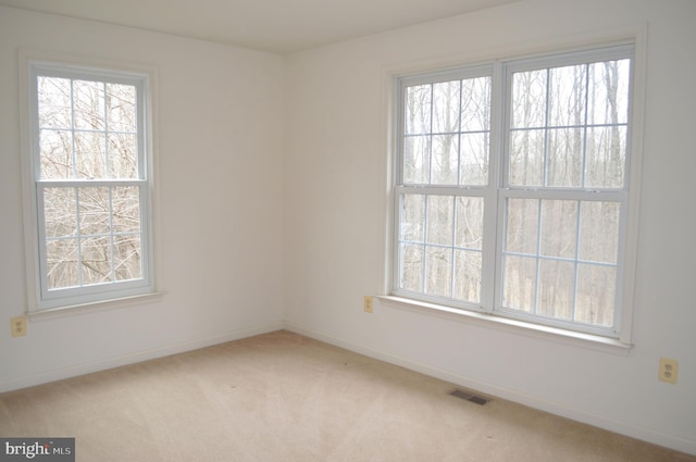 spare room featuring visible vents, baseboards, and carpet floors