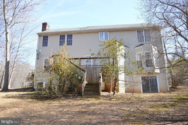 rear view of property featuring stairway, cooling unit, and a chimney