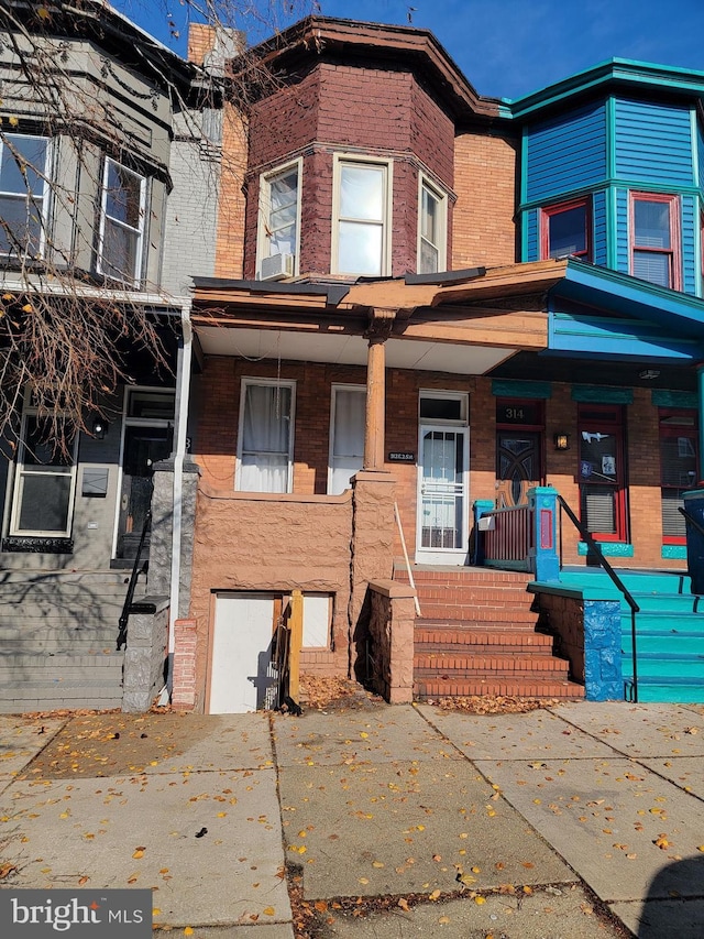 multi unit property featuring covered porch and brick siding