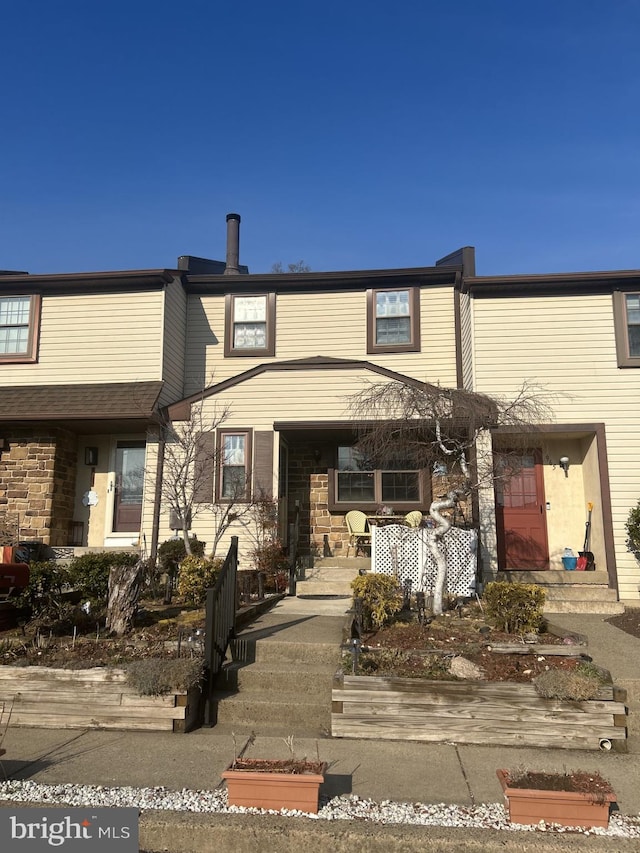 view of property featuring a porch and stone siding