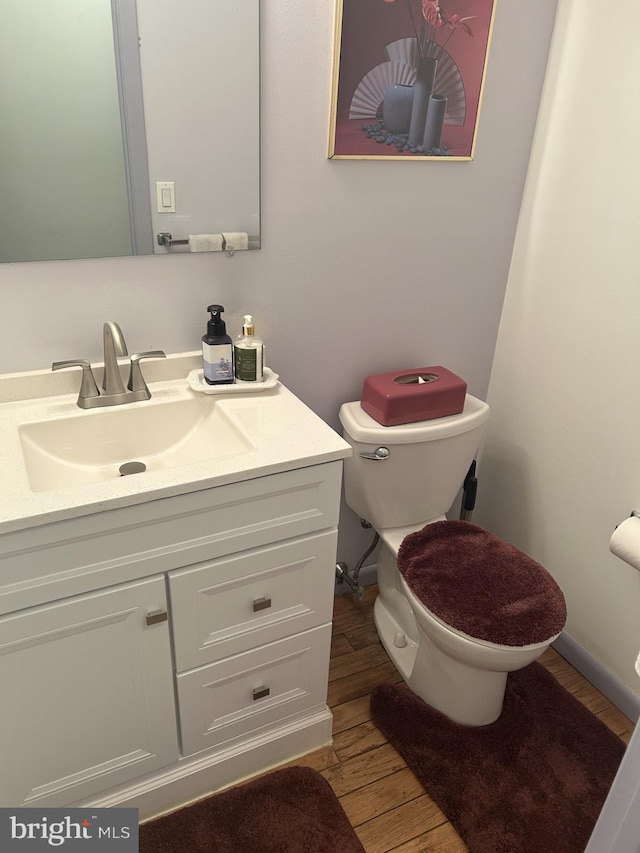 bathroom featuring toilet, wood finished floors, and vanity