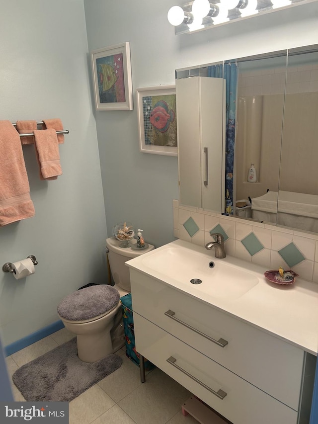 bathroom with tile patterned flooring, toilet, vanity, a shower with curtain, and tasteful backsplash