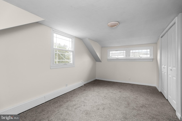 bonus room featuring a baseboard heating unit, vaulted ceiling, carpet, and baseboards