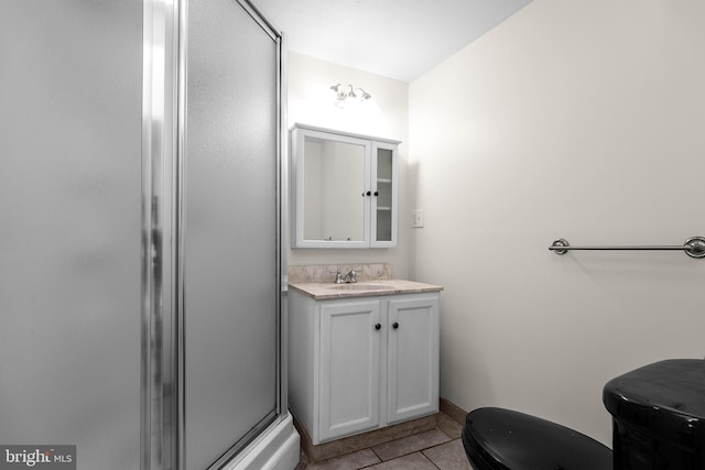 full bath with toilet, a shower stall, vanity, and tile patterned floors