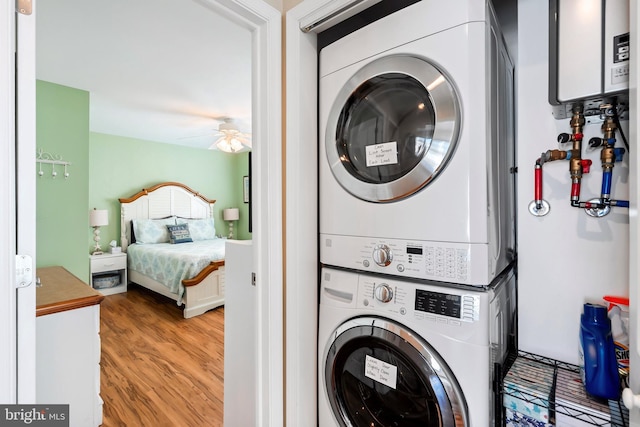 10 W Essex Ave, Harvey Cedars, NJ 08008 - laundry room featuring estacked washer and dryer, light wood finished floors, a ceiling fan, and water heater