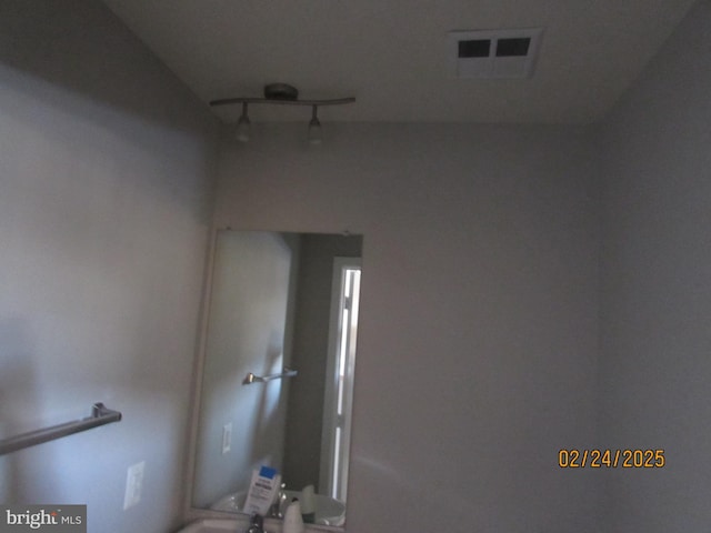 bathroom featuring rail lighting and visible vents