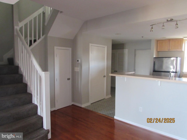 kitchen featuring a peninsula, wood finished floors, and freestanding refrigerator