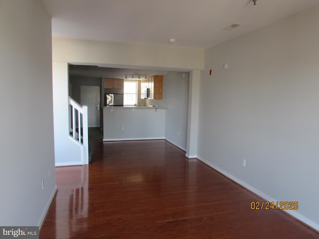 interior space with stairs, dark wood-style flooring, visible vents, and baseboards