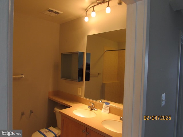 bathroom with double vanity, walk in shower, a sink, and visible vents