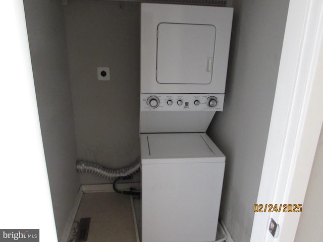 washroom with stacked washer / drying machine and laundry area