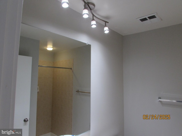 full bath with a tile shower and visible vents