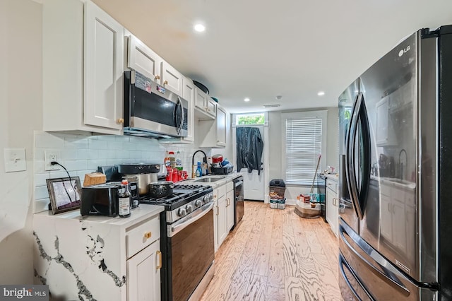 5312 Cordelia Ave, Baltimore, MD 21215 - kitchen featuring stainless steel appliances, light wood-style floors, light countertops, recessed lighting, and white cabinetry