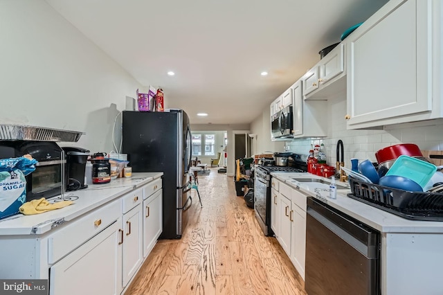 5312 Cordelia Ave, Baltimore, MD 21215 - kitchen with appliances with stainless steel finishes, light wood-type flooring, decorative backsplash, white cabinetry, and recessed lighting