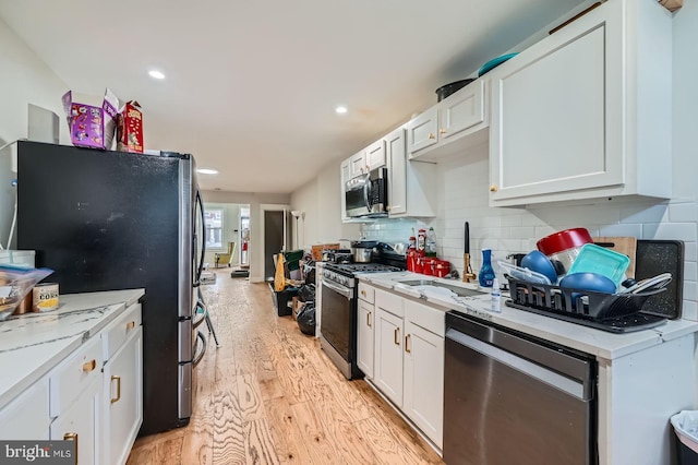 5312 Cordelia Ave, Baltimore, MD 21215 - kitchen featuring stainless steel appliances, light wood-style floors, white cabinetry, backsplash, and recessed lighting