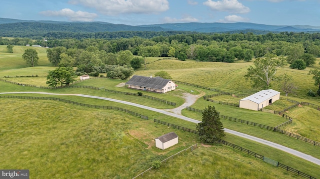 birds eye view of property featuring a rural view, a wooded view, and a mountain view