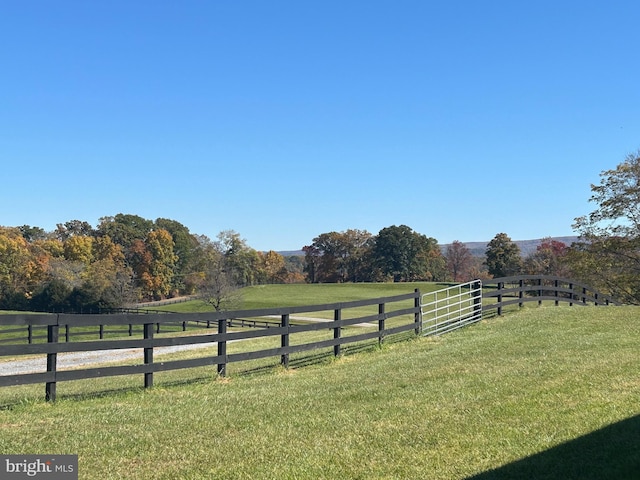 view of yard with a rural view and fence