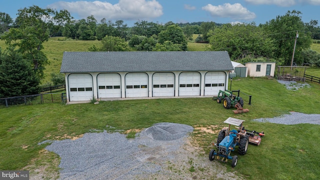 detached garage featuring driveway and fence