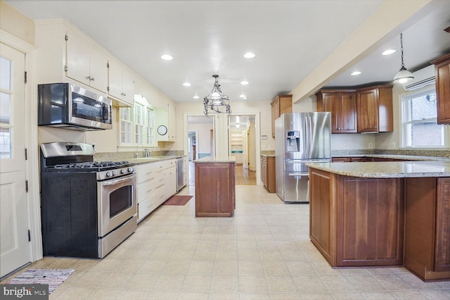 kitchen with pendant lighting, recessed lighting, appliances with stainless steel finishes, a sink, and a kitchen island