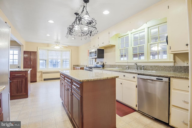 kitchen with radiator, ceiling fan, hanging light fixtures, stainless steel appliances, and recessed lighting