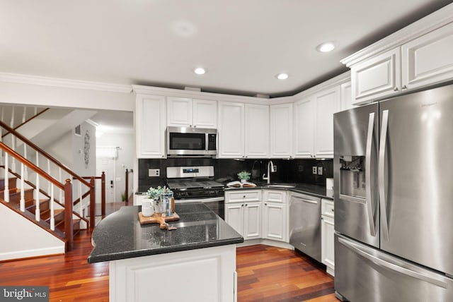 kitchen featuring white cabinets, a sink, stainless steel appliances, and backsplash