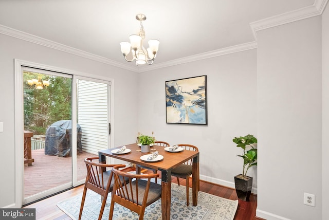 dining room featuring a chandelier, light wood-type flooring, crown molding, and baseboards