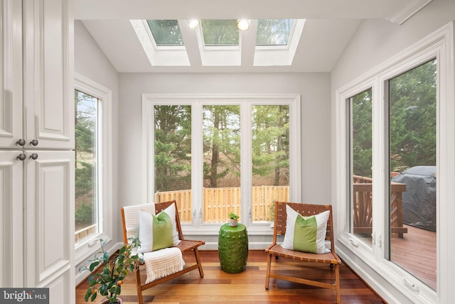 sunroom featuring vaulted ceiling with skylight