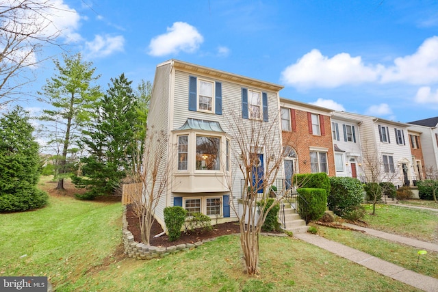 townhome / multi-family property featuring a front yard