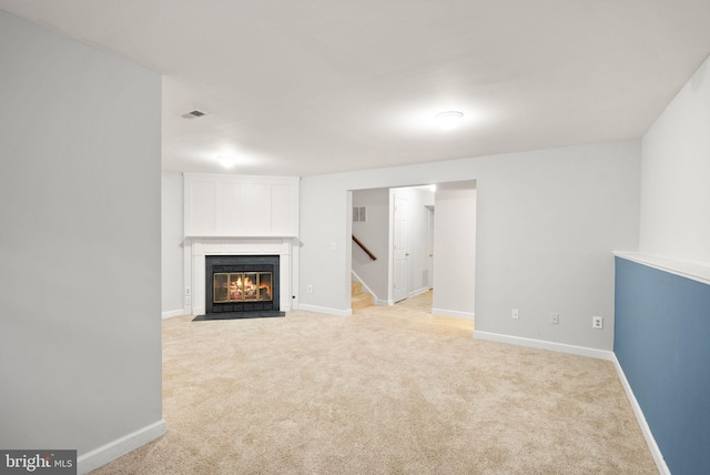 unfurnished living room featuring light carpet, visible vents, and baseboards