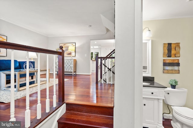 interior space with baseboards, wood finished floors, and crown molding