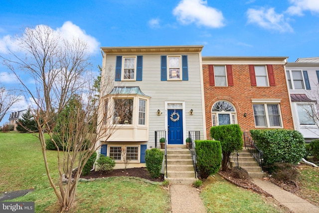 townhome / multi-family property featuring a front yard