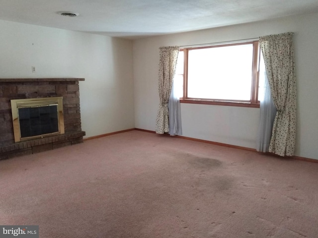 unfurnished living room featuring carpet, visible vents, baseboards, and a stone fireplace