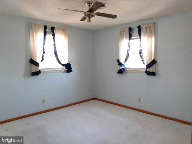 empty room featuring a ceiling fan, light carpet, and baseboards