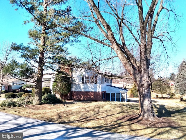 view of property exterior featuring a sunroom and brick siding