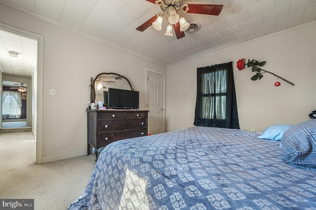 carpeted bedroom featuring baseboards, ceiling fan, multiple windows, and crown molding