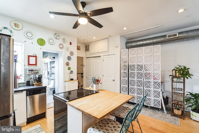 kitchen with recessed lighting, visible vents, a kitchen breakfast bar, light wood-style floors, and appliances with stainless steel finishes