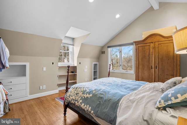 bedroom with multiple windows, baseboards, light wood-type flooring, and vaulted ceiling with beams