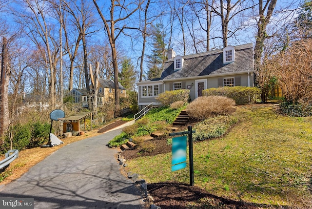 view of front of home featuring driveway and a chimney