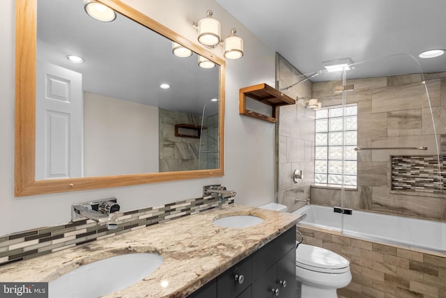 full bath featuring toilet, a sink, tiled shower / bath combo, recessed lighting, and double vanity