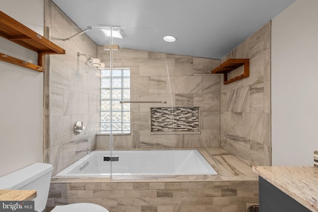 bathroom featuring toilet, vanity, and tiled shower / bath combo